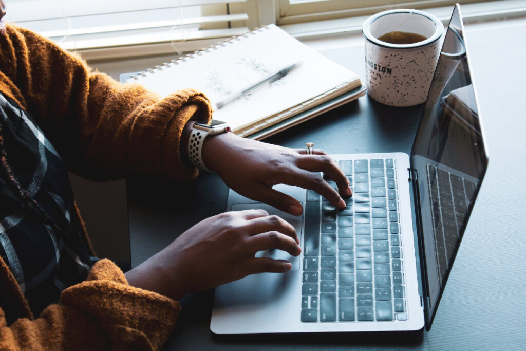 Mulher negra usando um computador - Foto de Daniel Thomas na Unsplash